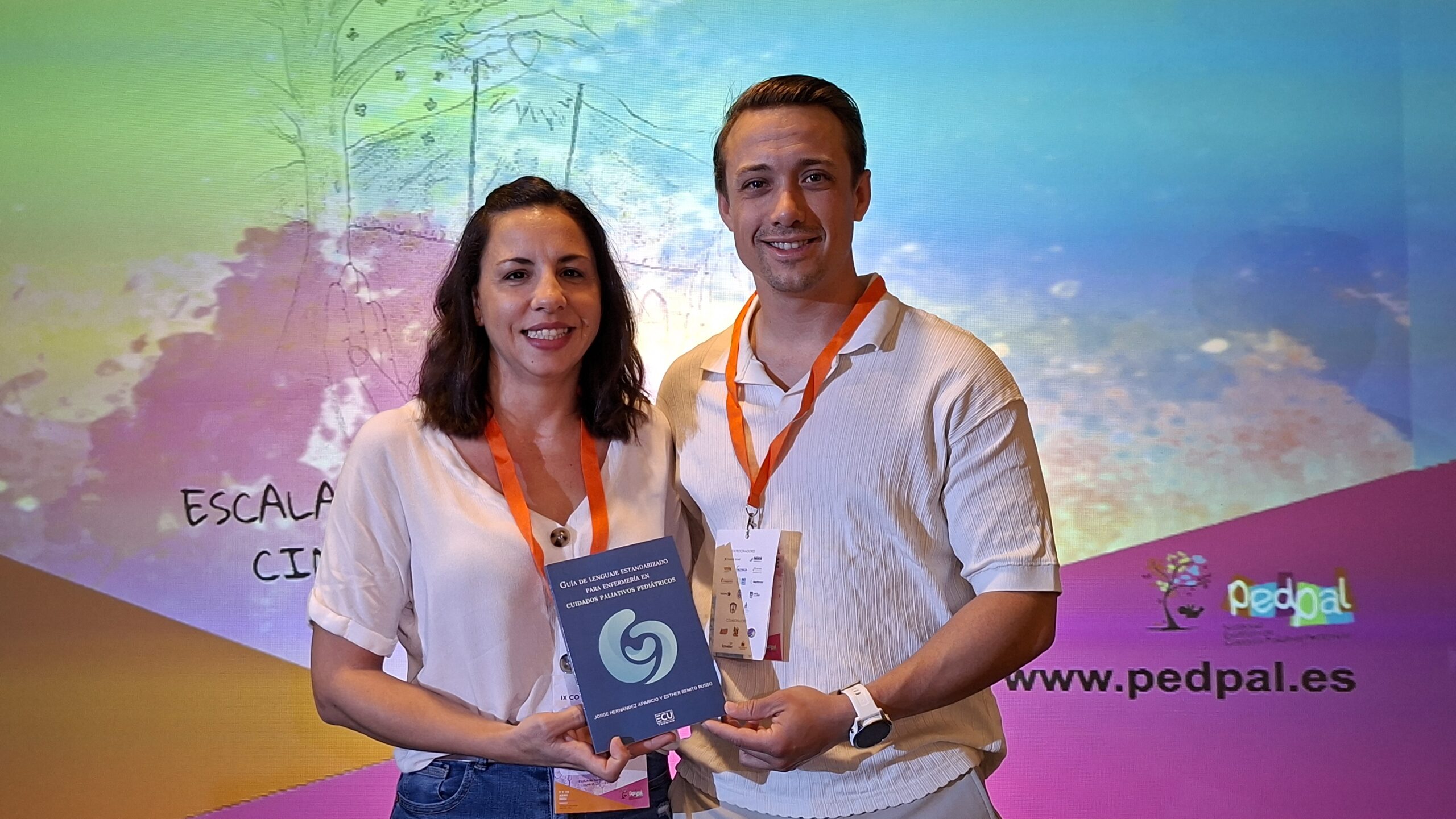 Jorge Hernández y Esther Benito presentan un ejemplar de la Guía de Lenguaje Estandarizado para Enfermería en Cuidados Paliativos Pediátricos.